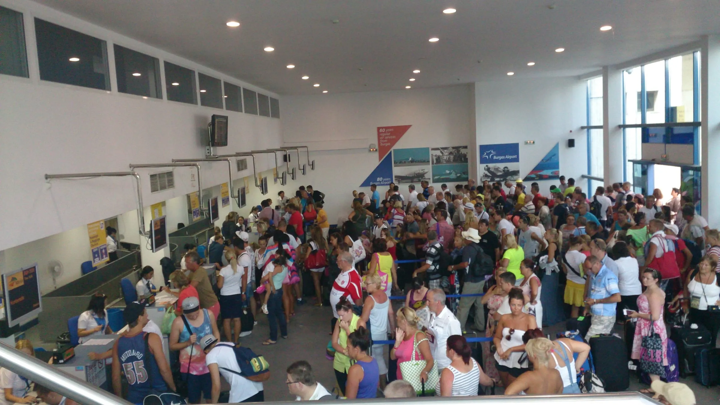 A crowded check-in hall at Burgas Airport during the summer charter season