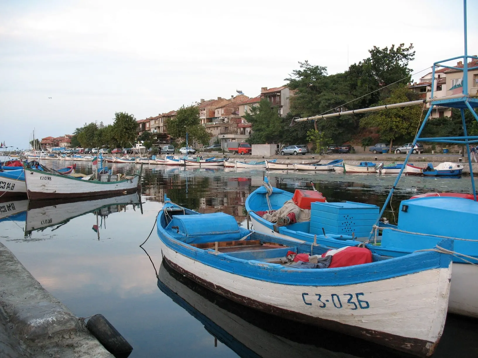Blue and white fishing boats moored in Sozopol harbour at dusk