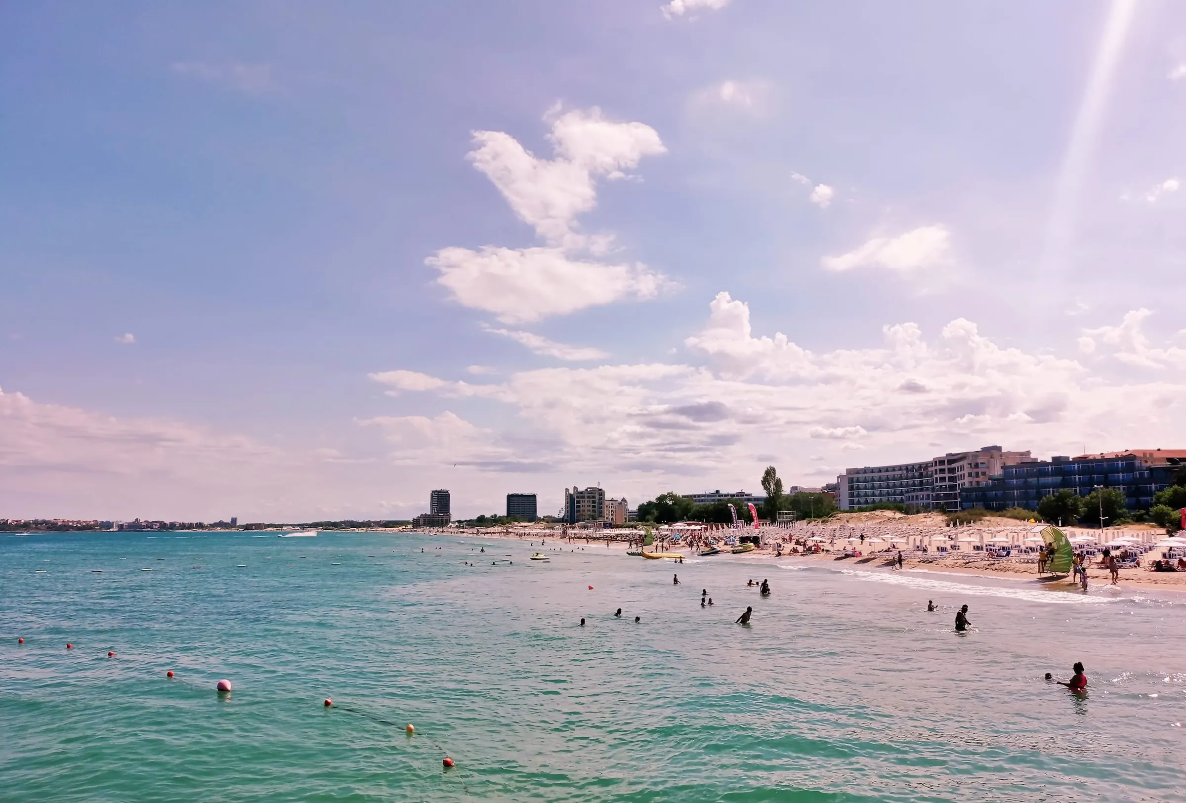 The long curve of Sunny Beach's shoreline with hotel blocks behind the sand